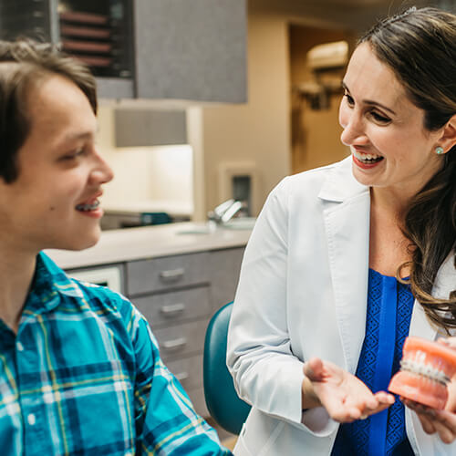 Schedule your orthodontic consultation Dr. Patra talking to her teenager patient about braces